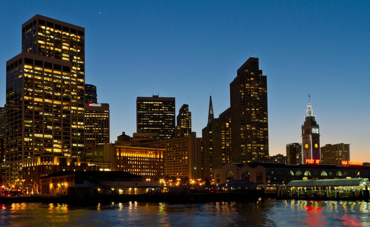 San Francisco skyline and Ferry Building illuminated at twilight along the Embarcadero waterfront