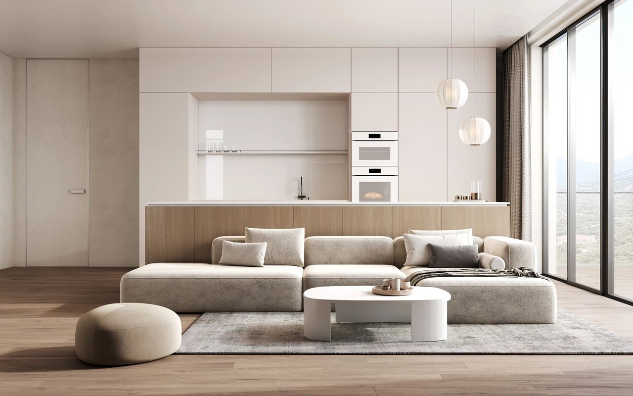 Modern living room with a cream sectional and open kitchen beside floor-to-ceiling windows.