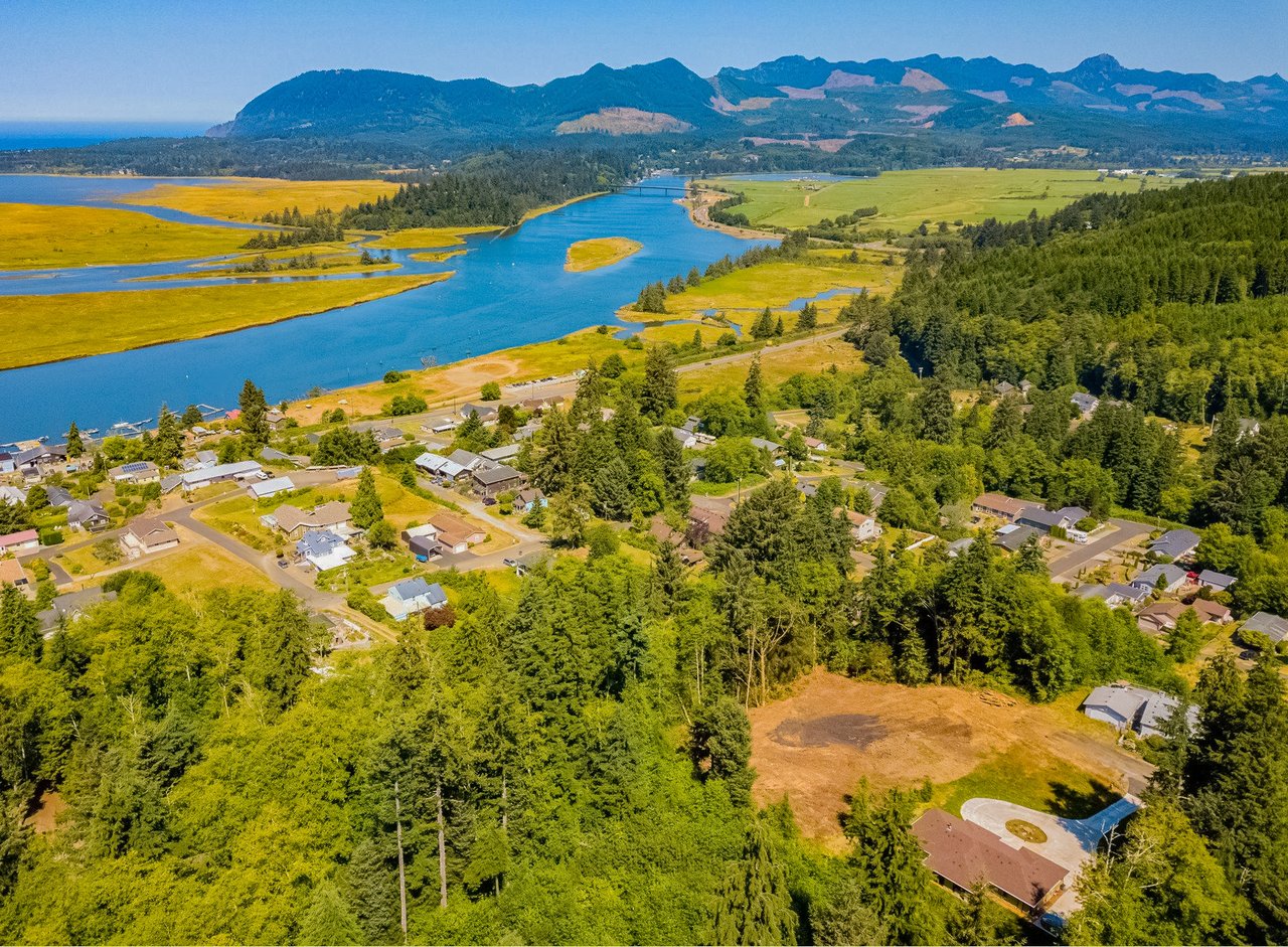 Sold Wheeler land at Cedar St Unit 4901 in Wheeler Oregon represented by Erin Laskey of Home + Sea Realty with 0.68 acres, peek Nehalem River and mountain views, privacy, and development potential.