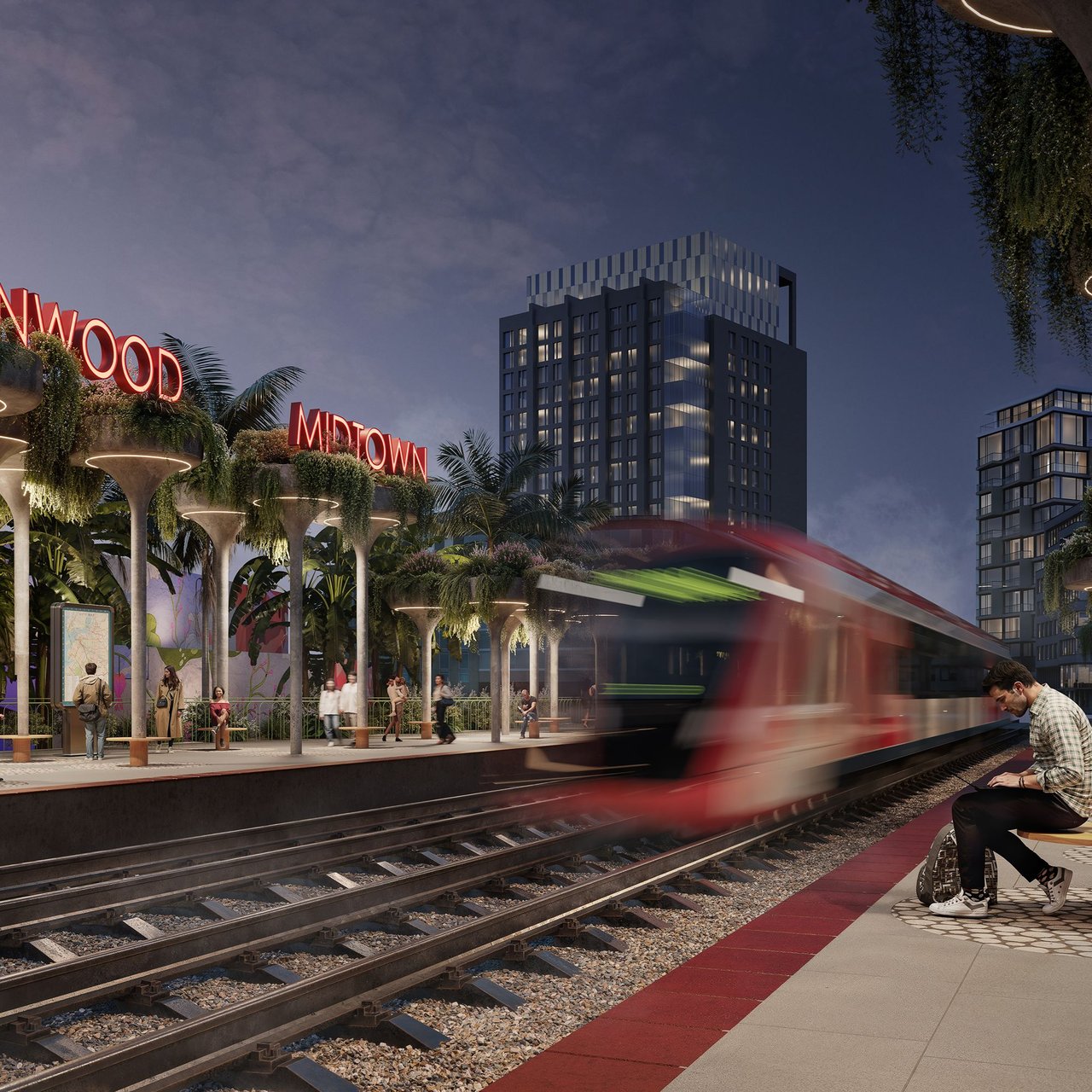Residential tower beside a tropical rail station as a train passes at dusk.