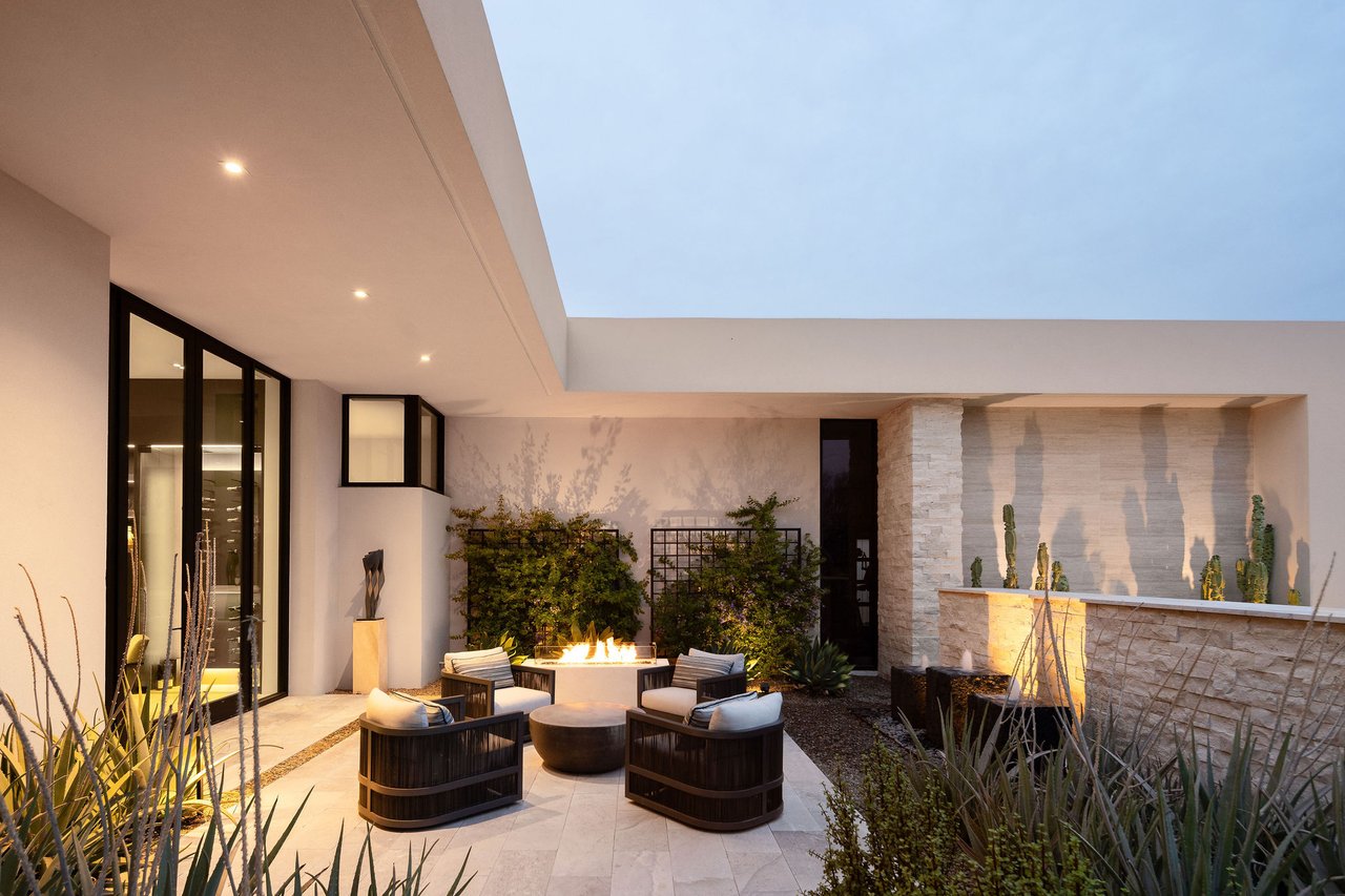 Modern luxury home in Paradise Valley with resort-style backyard, pool, fire feature, and contemporary architecture at sunset.