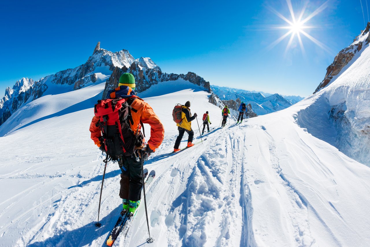 A skier carving through deep powder in the backcountry of Jackson Hole Mountain Resort with breathtaking Teton views in the background.