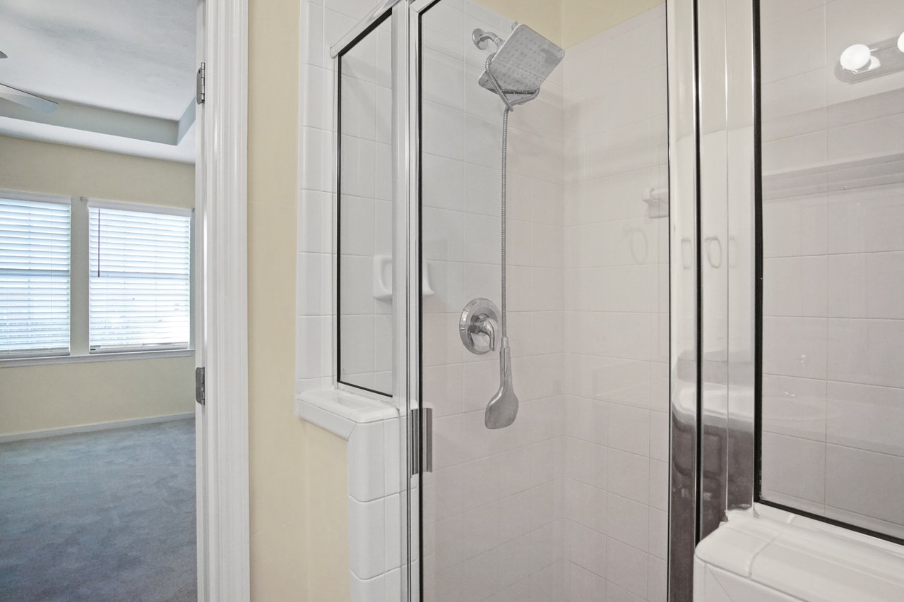 Primary bathroom at 5441 Hampton Hill Circle, Tallahassee, Florida 32311 featuring tiled walk-in shower with glass door and chrome fixtures.