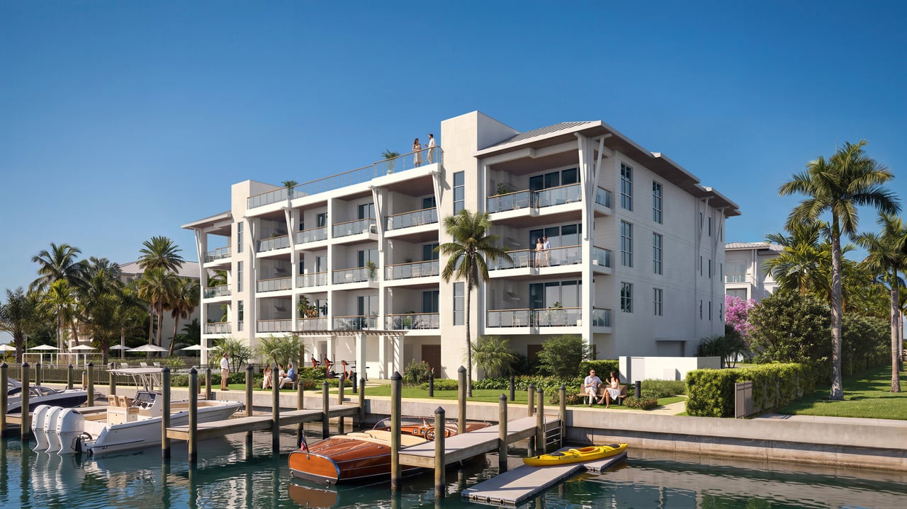 Modern waterfront condominium with broad balconies overlooking a marina and boats.