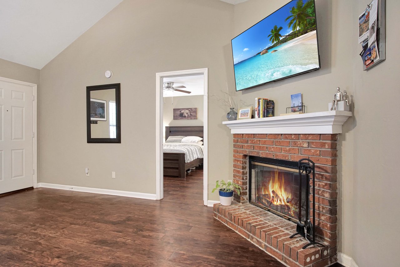 A cozy living room featuring a fireplace and a flat-screen TV, creating a warm and inviting atmosphere.