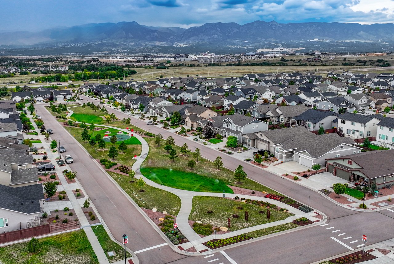 Aerial view of the neighborhood park and tree-lined streets toward the mountains