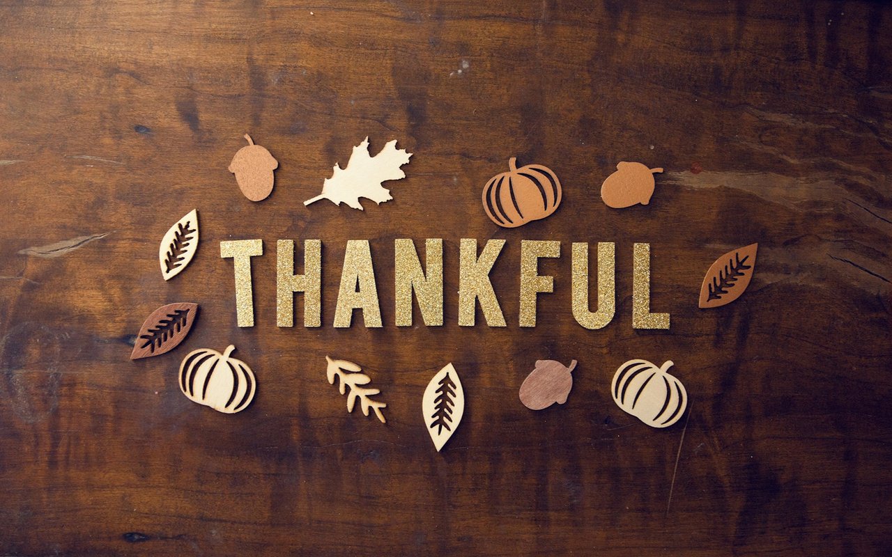 Wooden “THANKFUL” letters surrounded by cutout autumn leaves, acorns, and pumpkins.