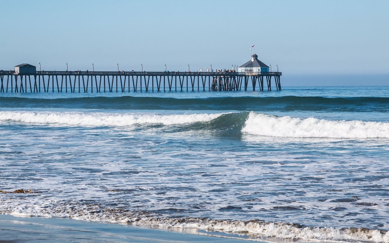 Imperial Beach Pier extends over breaking surf.