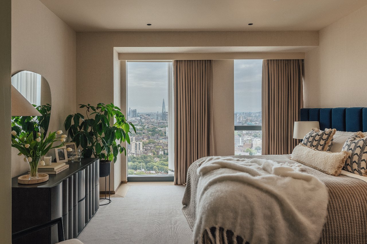 Furnished bedroom with a blue headboard and city views including The Shard.
