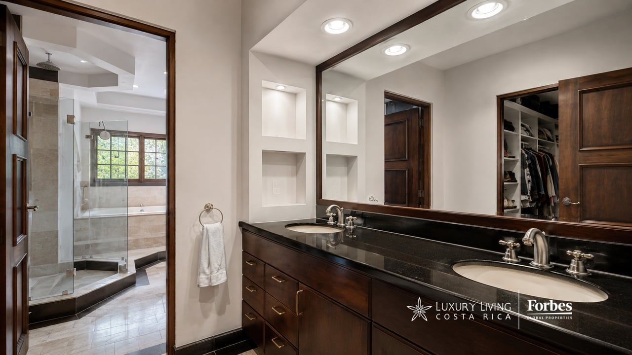 Bathroom with a dark wood double vanity and a glass shower beside a bathtub.