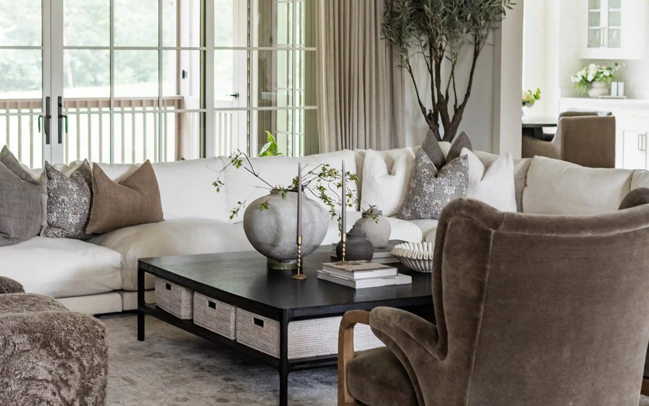 Furnished living room with a white sectional, black coffee table, and tall glass doors to a balcony.