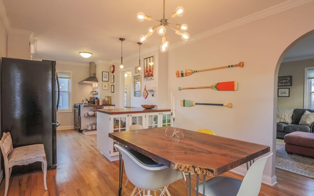 Open-plan kitchen and dining area with a live-edge table and decorative oars on the wall.