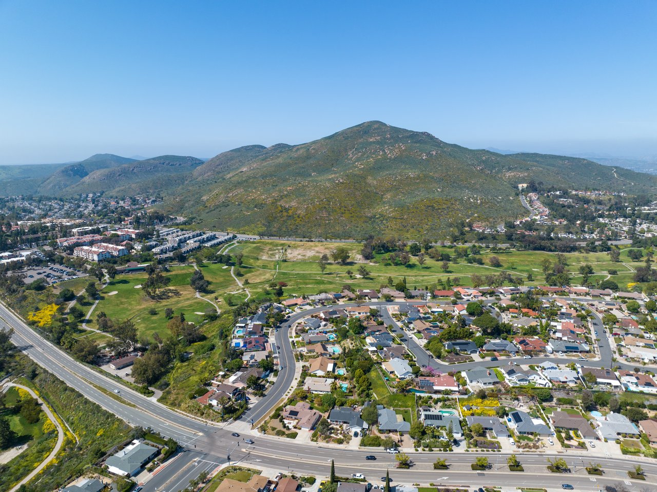 Aerial view of Santee homes and parkland beneath a prominent scrub-covered mountain.