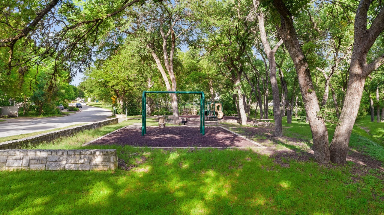 Tree-lined neighborhood street and park near 34 Margranita Crescent, Tarrytown, Austin, TX.