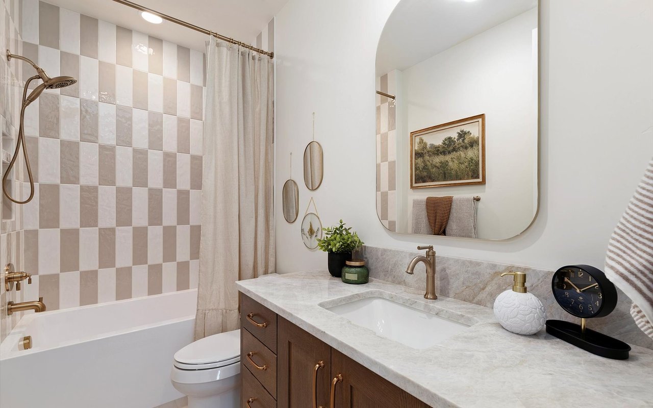 Upstairs guest bathroom featuring a checkerboard pattern of cream and beige shower tiles