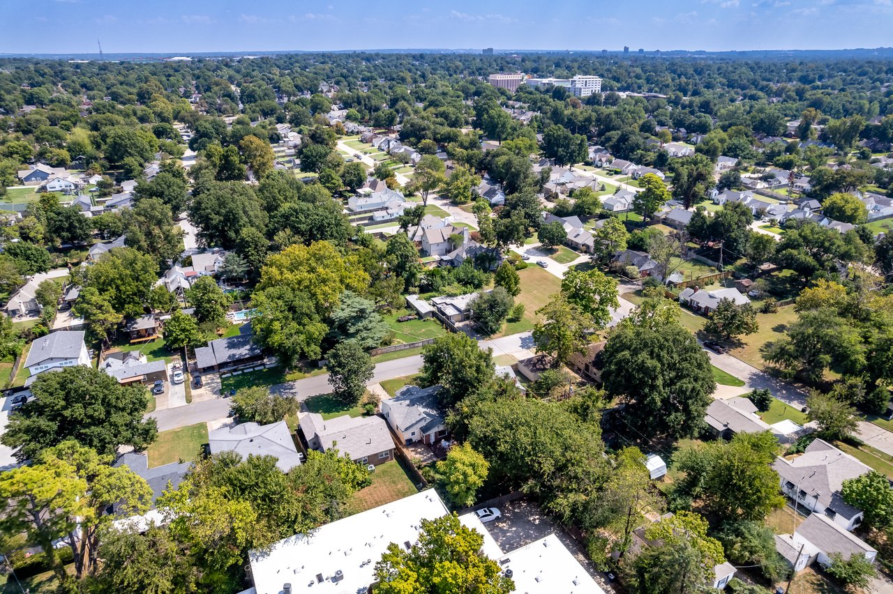 Aerial view of a leafy neighborhood with detached homes and tree-lined streets.