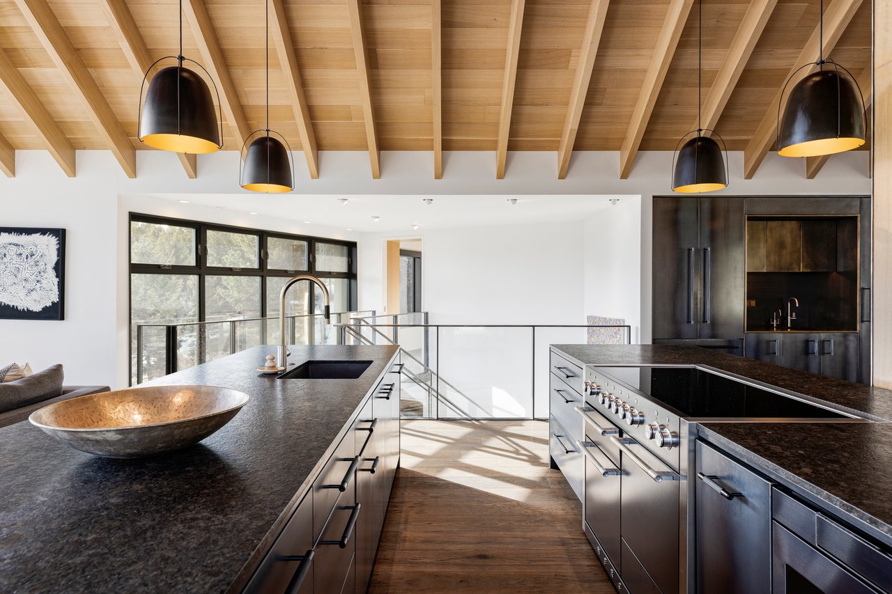 Modern Boulder mountain home kitchen with dual islands, stainless appliances, and exposed wood beam ceiling