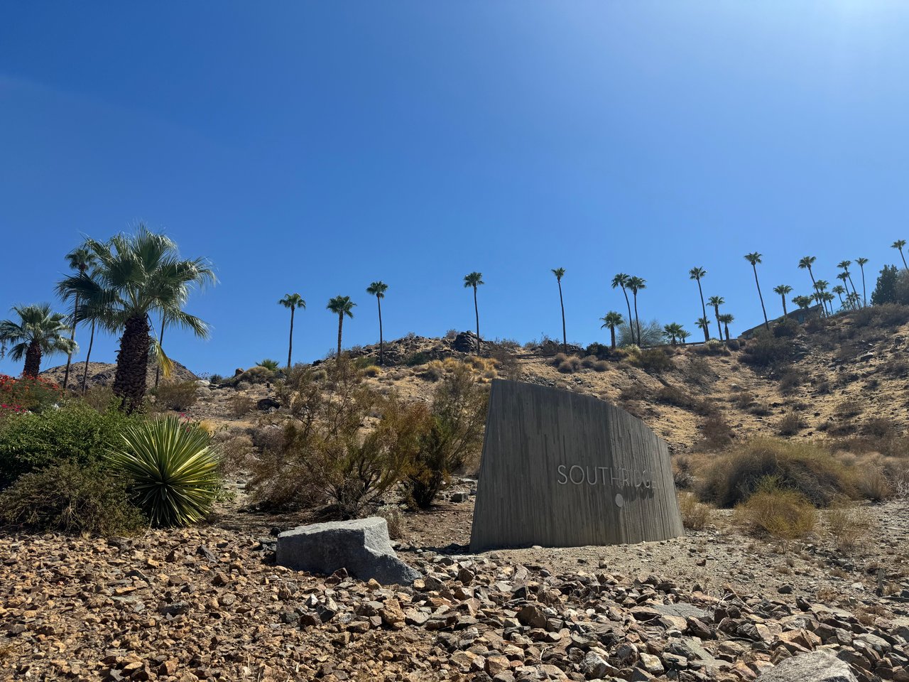 Southridge community entrance sign on a rocky hillside with palm trees.