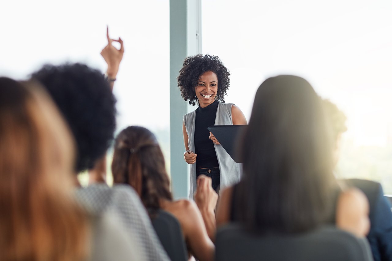 Female instructor leading interactive training session with engaged real estate agents.