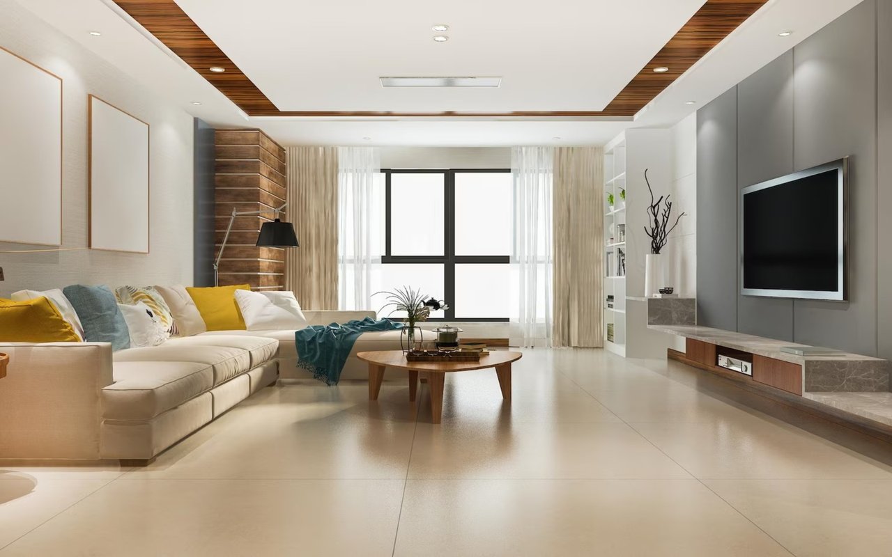 Modern living room with a cream sectional, colorful cushions, and wall-mounted television.