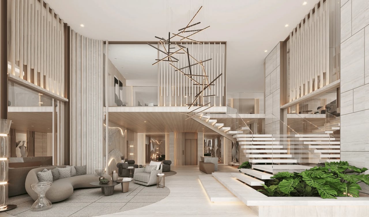 Luxury condo lobby with a sculptural chandelier, floating staircase, and indoor planting.