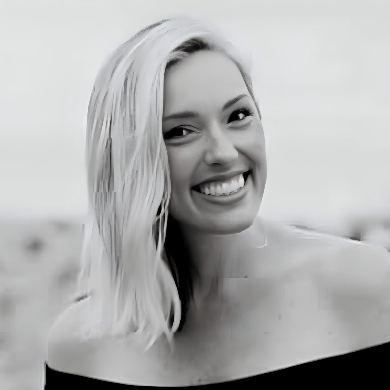 Smiling woman with long, light-colored hair in a black-and-white headshot.