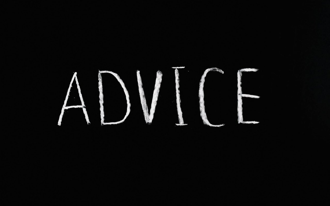 The word “ADVICE” written in white chalk on a black surface.