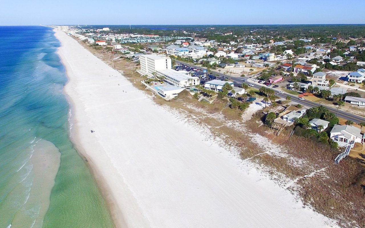 Panama City Beach’s white-sand shoreline and turquoise water beside beachfront homes.