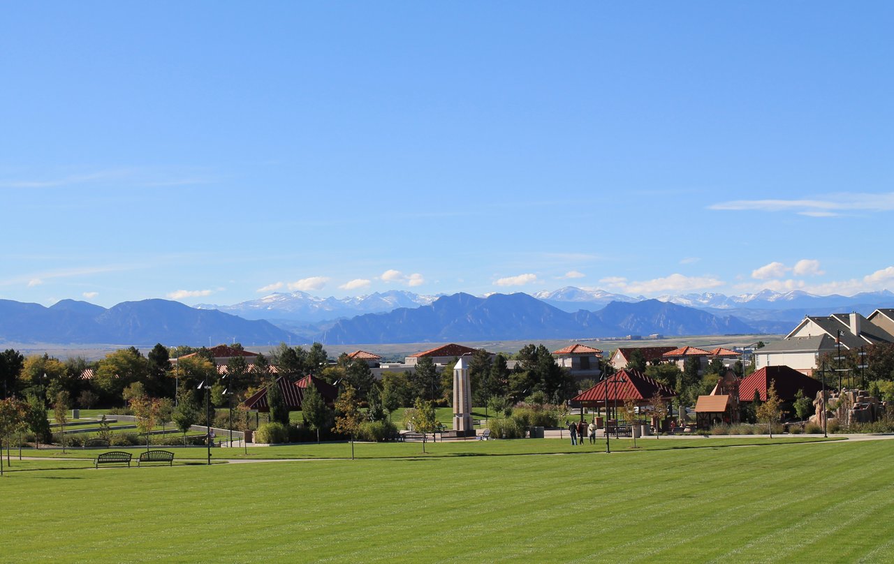 Denver park with Rocky Mountains in the background during spring real estate market season