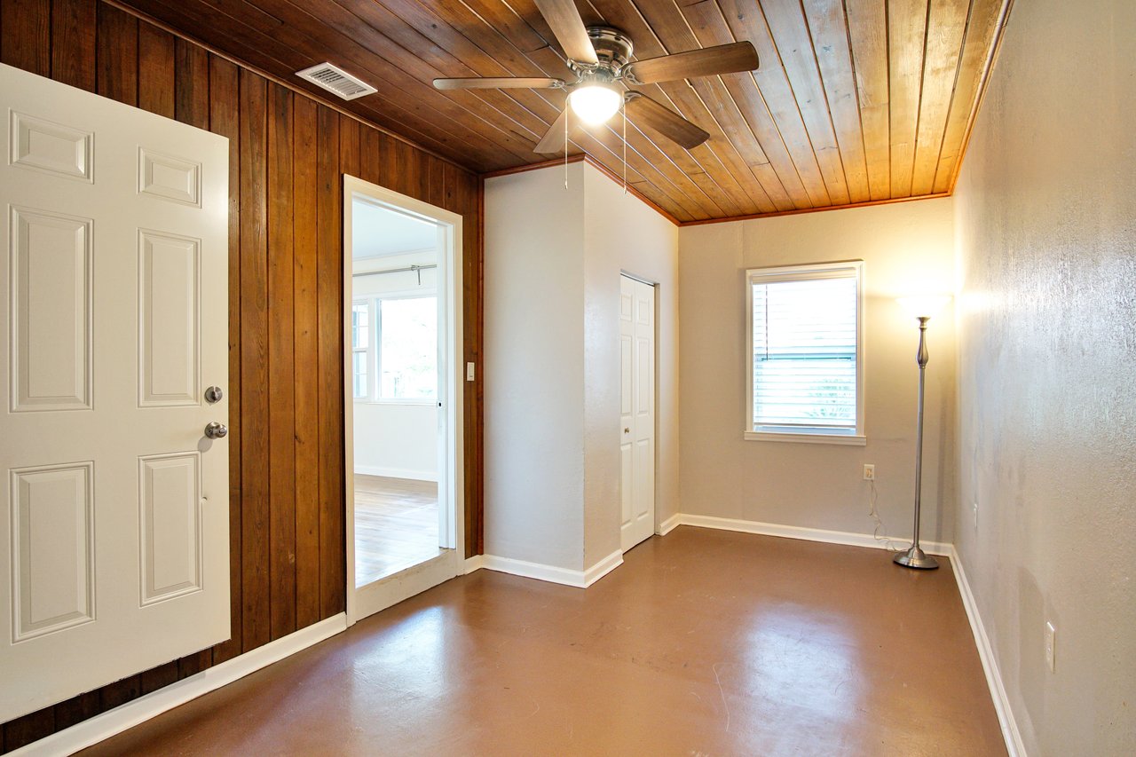 A hallway featuring wooden paneling and a ceiling fan, creating a warm and inviting atmosphere.