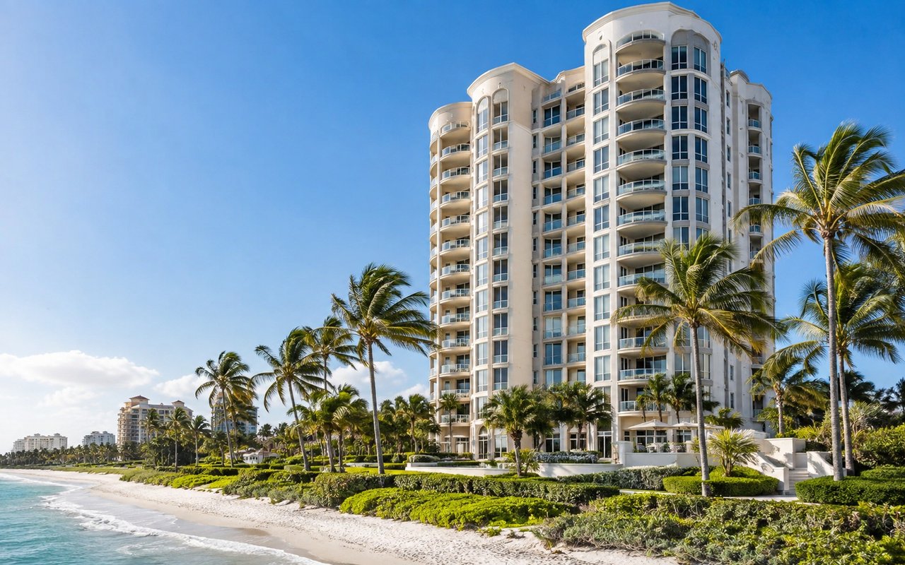 Allegro condominium tower beside a palm-lined sandy beach in Naples.
