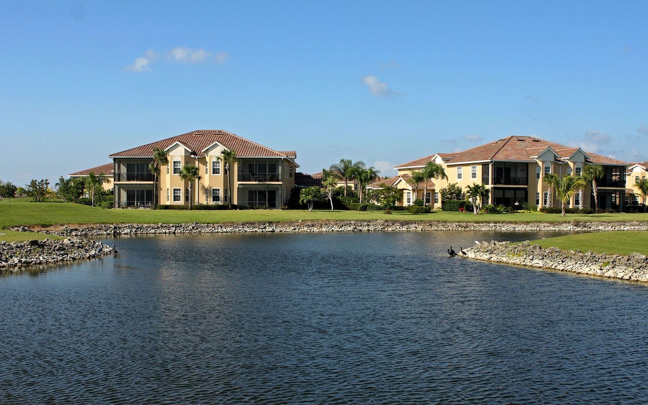 Twin Eagles residences along a lake, with tiled roofs and landscaped shores.