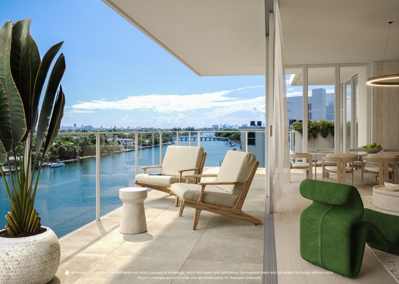 Furnished condo balcony with lounge chairs overlooking a waterway and distant skyline.