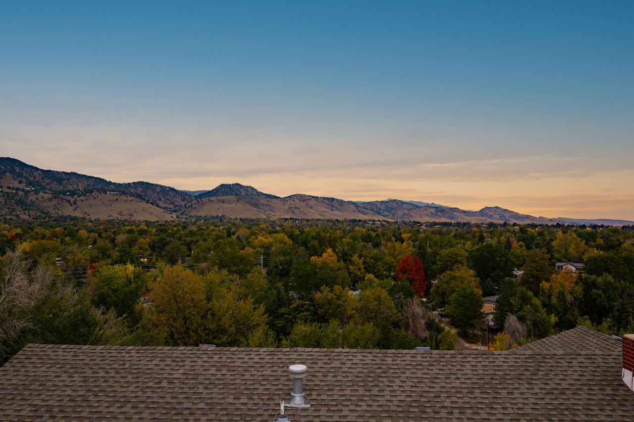 Evening view northwest from 2003 Balsam Drive over the roofline toward the foothills and fall trees