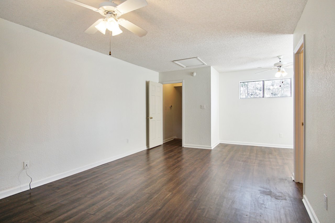 An empty room featuring hardwood floors and pristine white walls, creating a bright and spacious atmosphere.