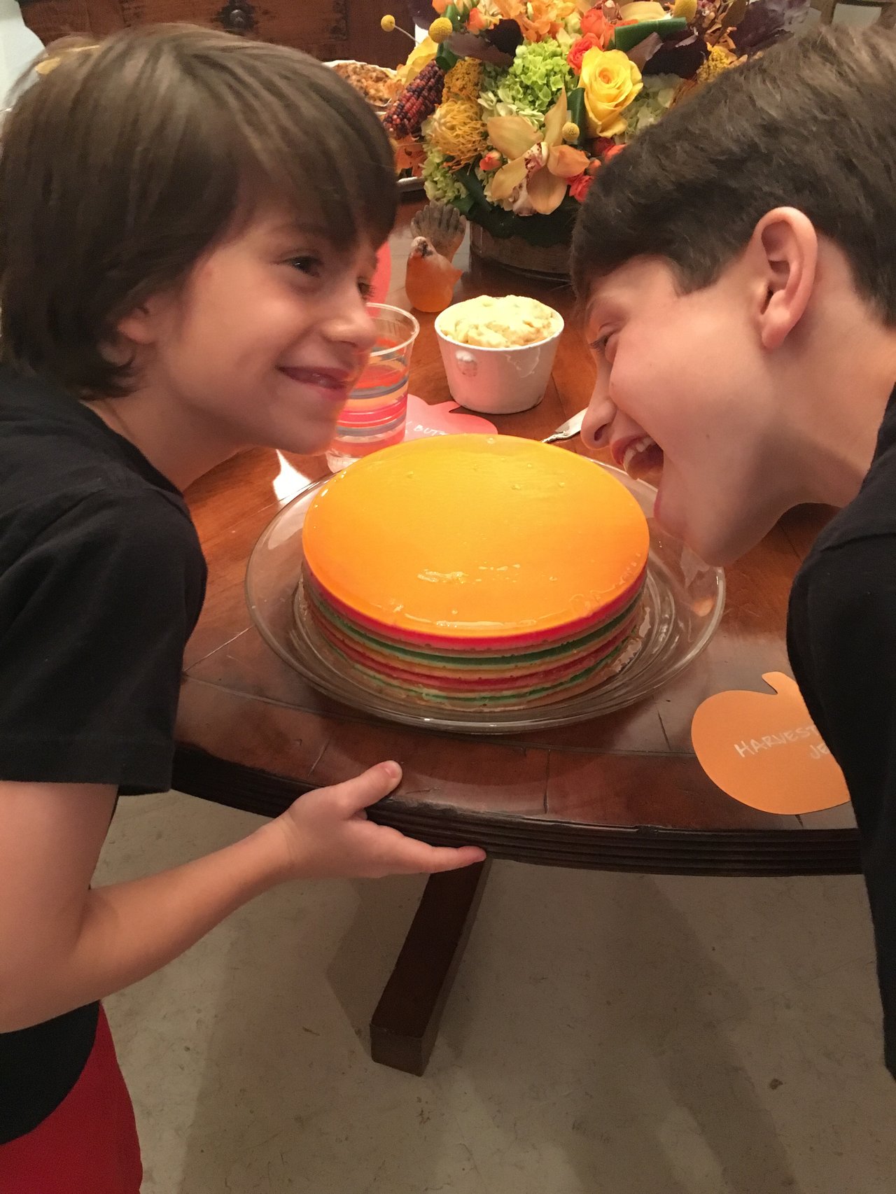 Layered rainbow Jell-O mold on a serving plate, sliced to show colorful layers.