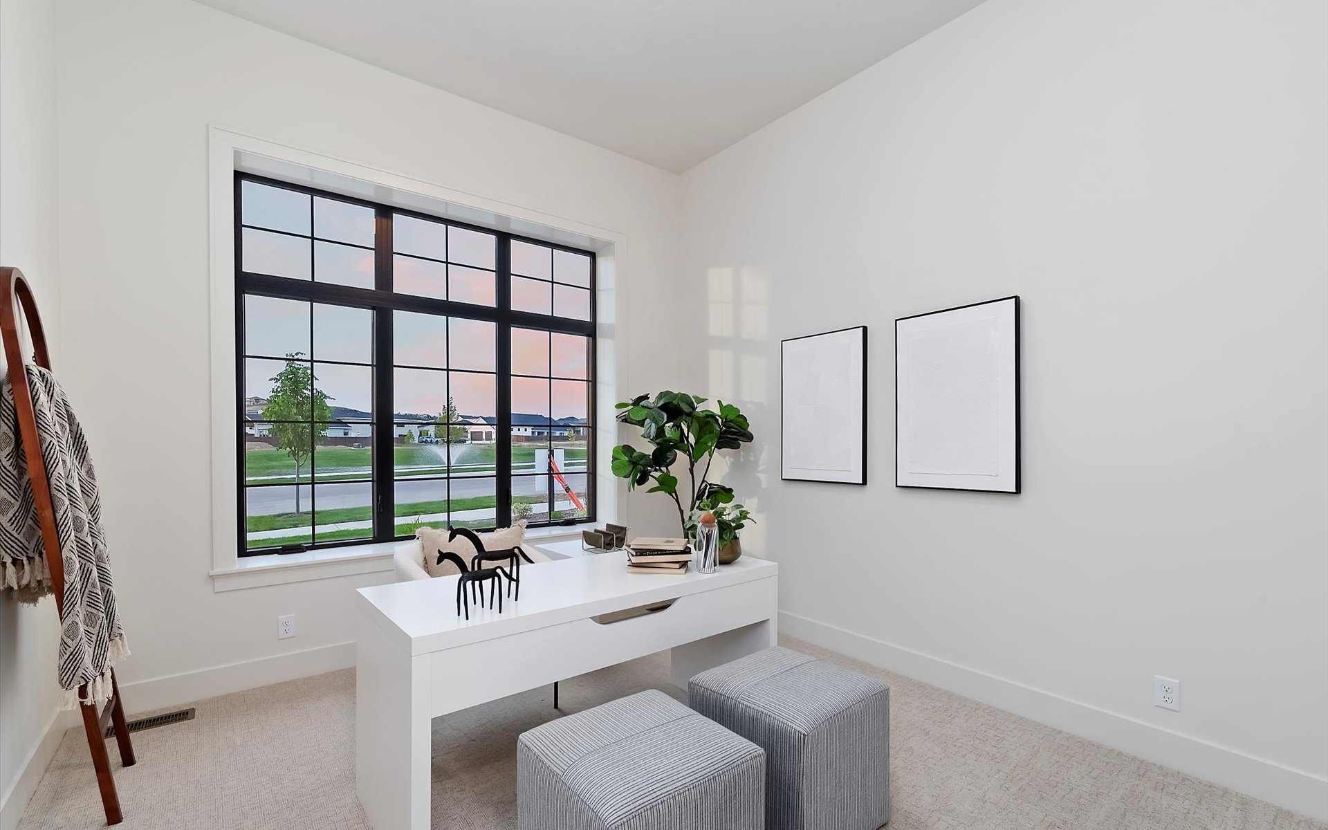 Home office in a new modern prairie home featuring black vinyl windows overlooking seasonal pond with fountain.