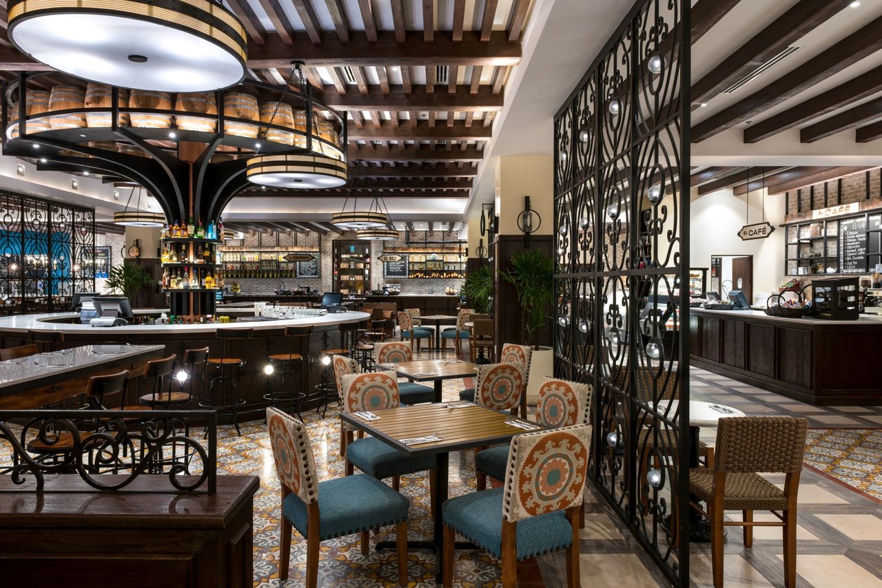 Quivira café and bar with a curved counter, patterned tile floors, and wood-beamed ceilings.