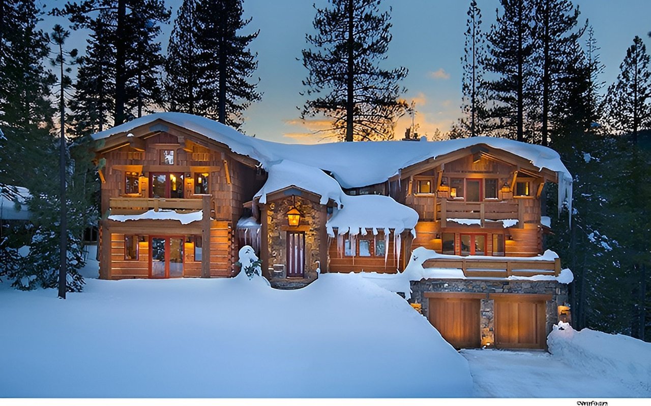 Snow-covered timber-and-stone ski lodge glowing at dusk among pine trees.