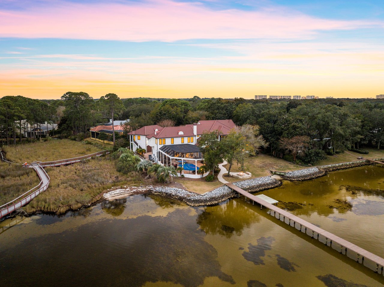 Stunning waterfront estate in Kelly Plantation featuring over an acre of lush landscaping, 220 feet of Choctawhatchee Bay frontage, and a private dock designed for a 75-foot yacht