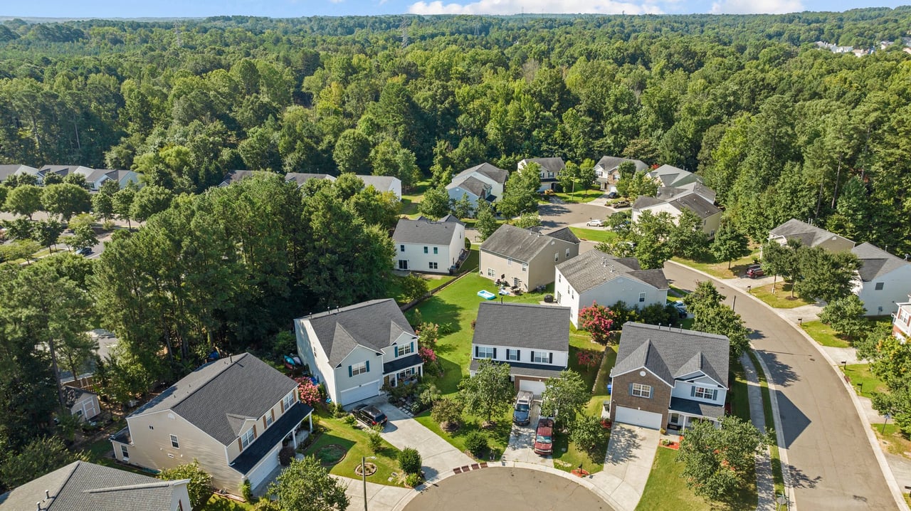 Aerial view of homes in a Raleigh area neighborhood representing the decision between renting and buying