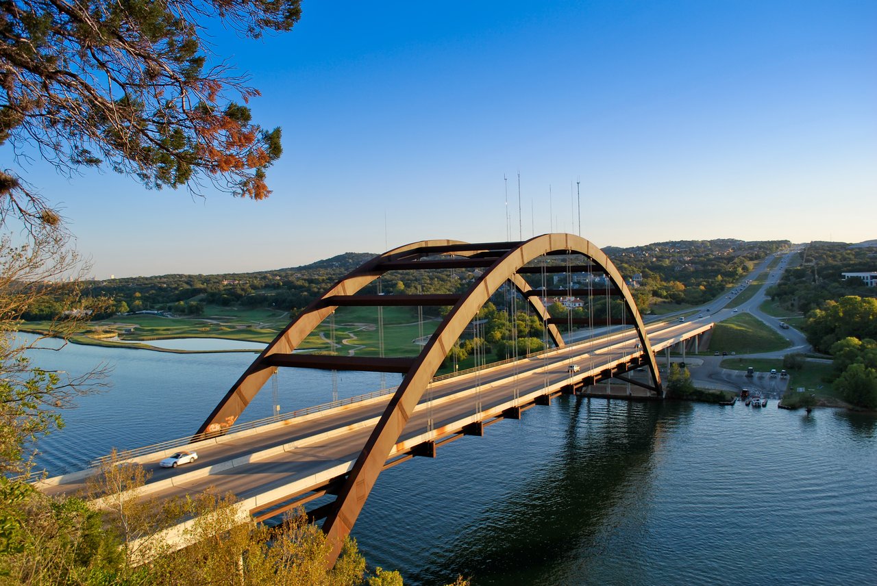 Austin’s Pennybacker Bridge crosses Lake Austin in warm evening light.