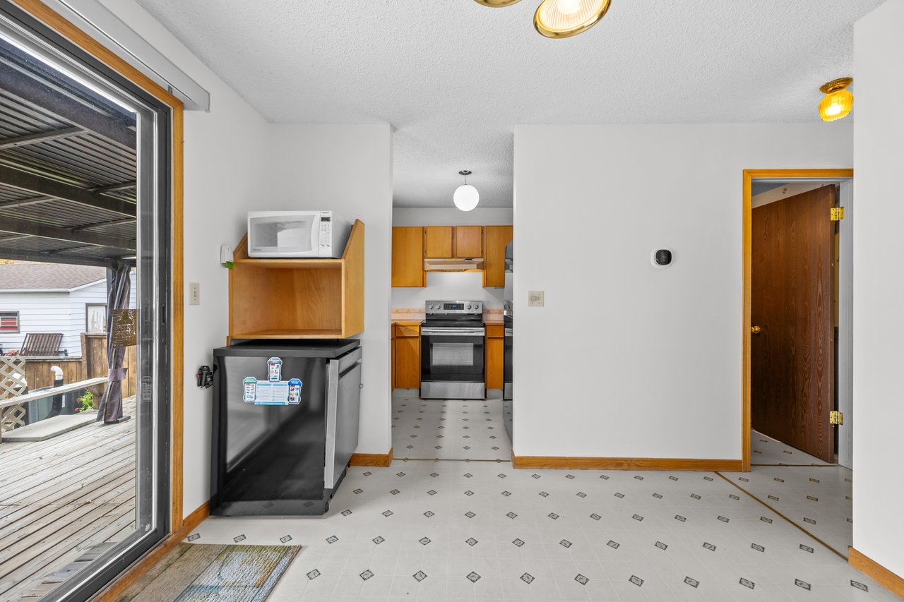 Kitchen with wood cabinets, a stainless steel range, patterned tile floor, and sliding doors to a deck.