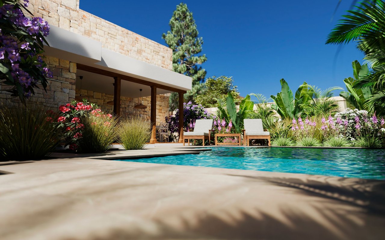 Outdoor pool beside a stone-clad home, framed by tropical greenery and colorful flowers.