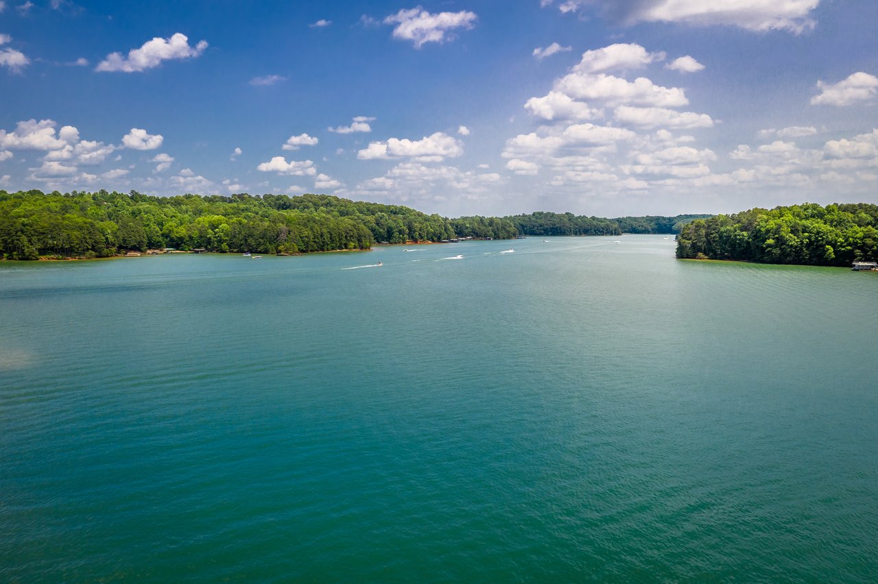 Wide view of Lake Oconee with wooded shoreline and boats on the water