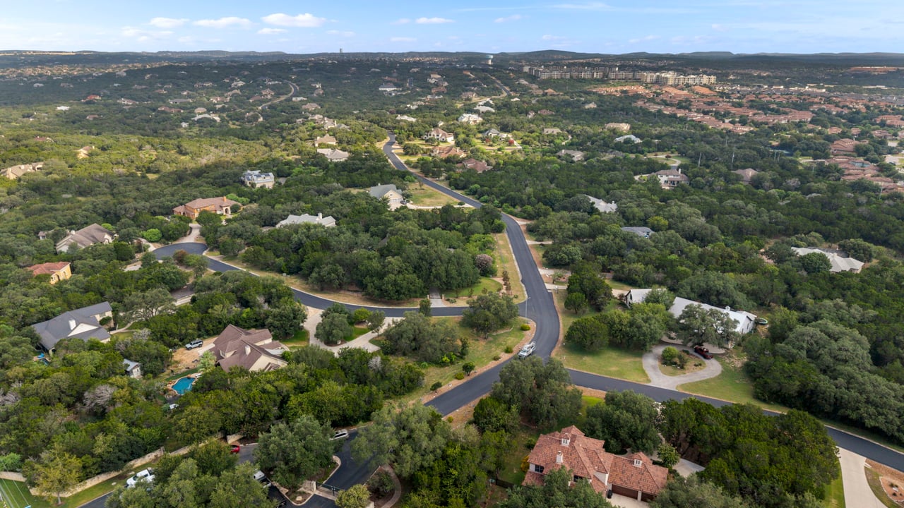 Aerial view of a leafy neighborhood with winding roads and detached homes.