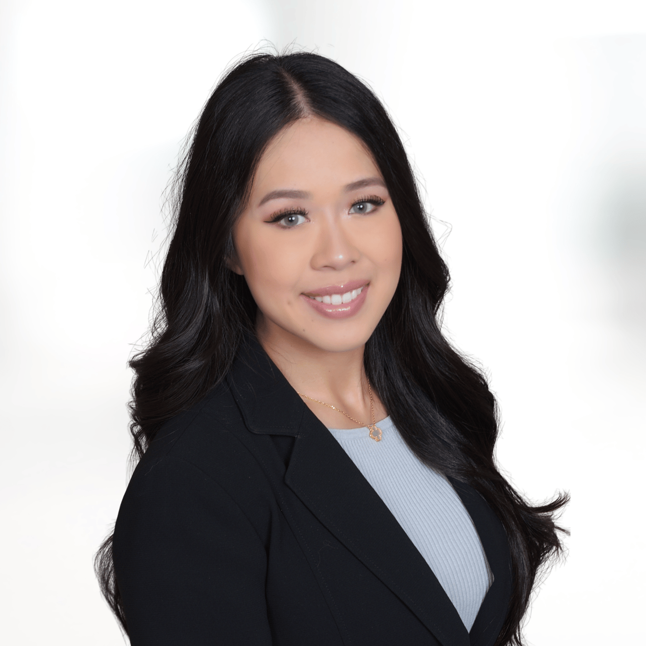 Viviane Nguyen smiling in a black blazer and light blue top.