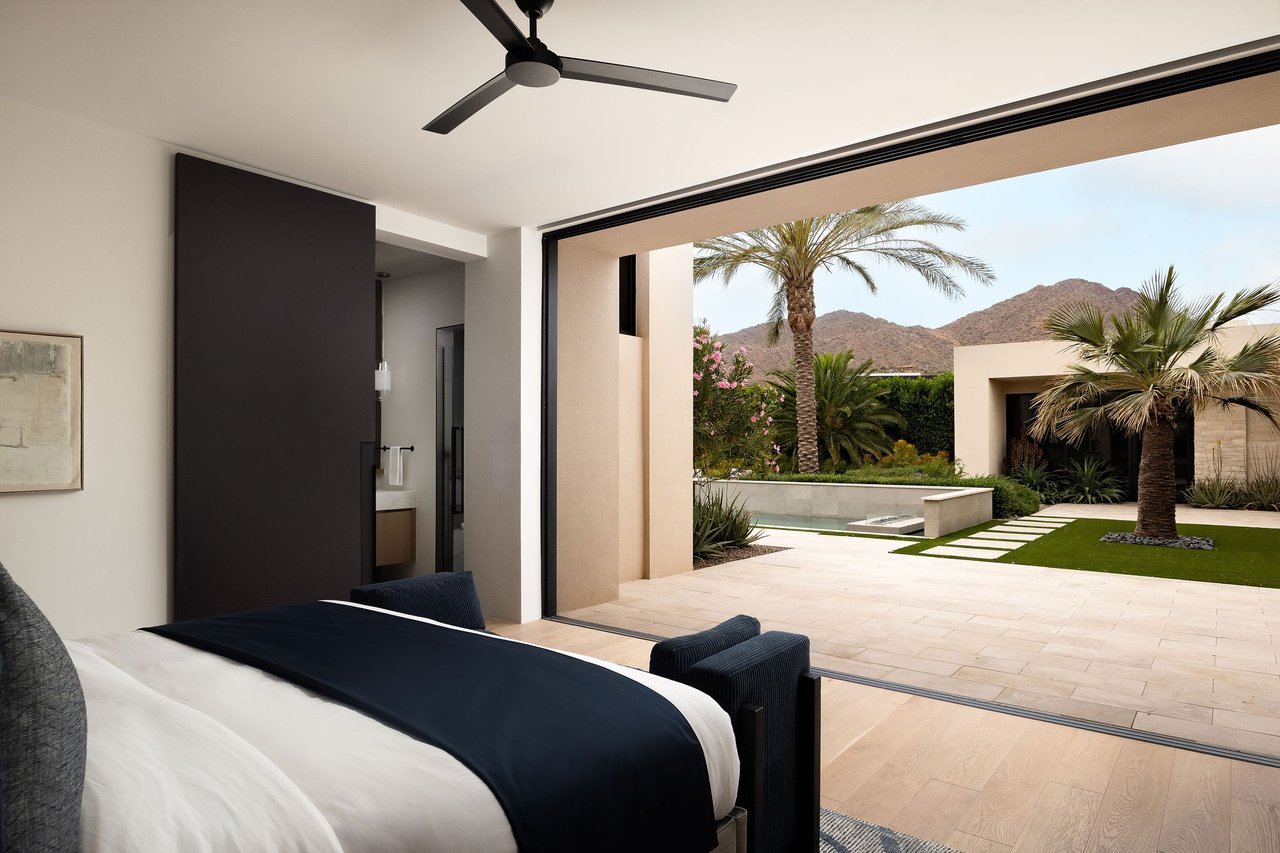 Modern luxury home in Paradise Valley with resort-style backyard, pool, fire feature, and contemporary architecture at sunset.