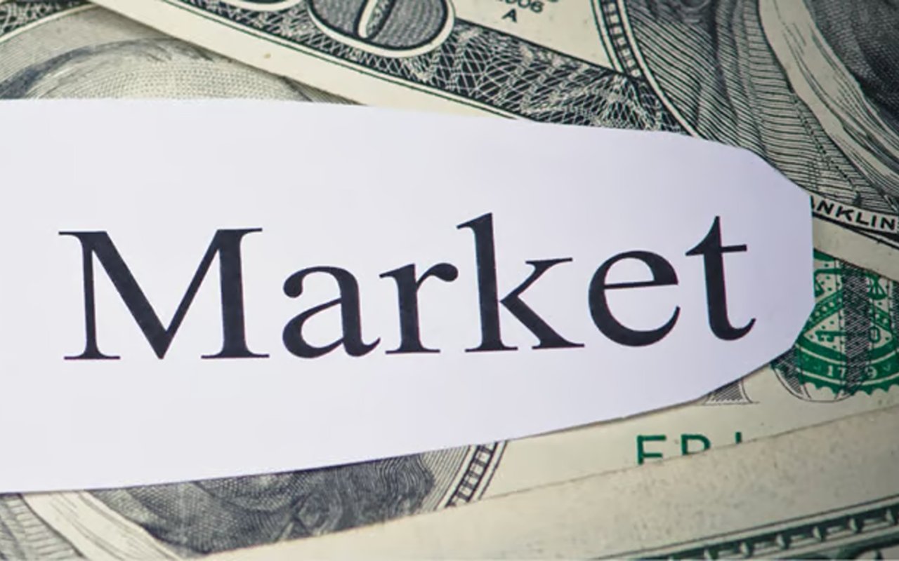 Paper labeled “Market” laid across U.S. dollar bills.