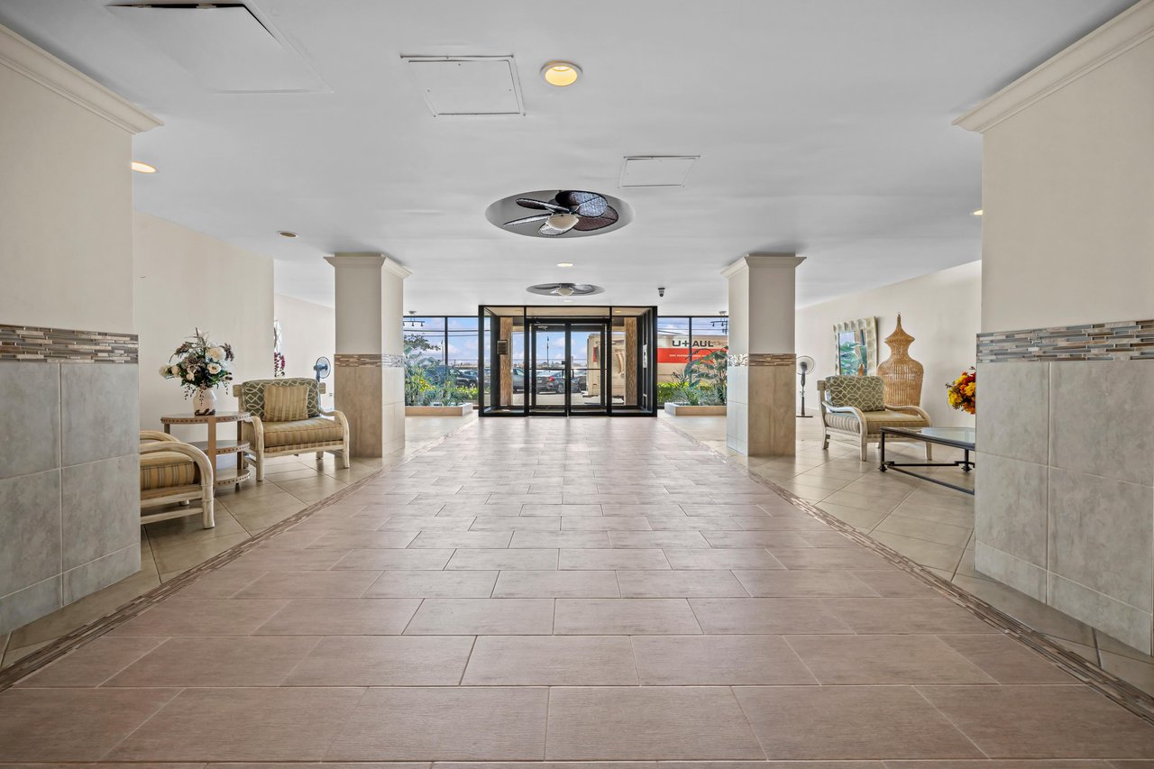 Cooperative building lobby with tiled floors, seating areas, and glass entry doors.